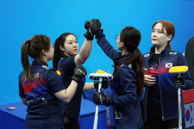 １７日午後、中国北京国家水泳センターで開かれた２０２２北京冬季オリンピック（五輪）カーリング女子団体戦の韓国とスウェーデンの競技に先立ち、チームキムの選手たちがハイタッチをしている。［写真　キム・ギョンロク記者］