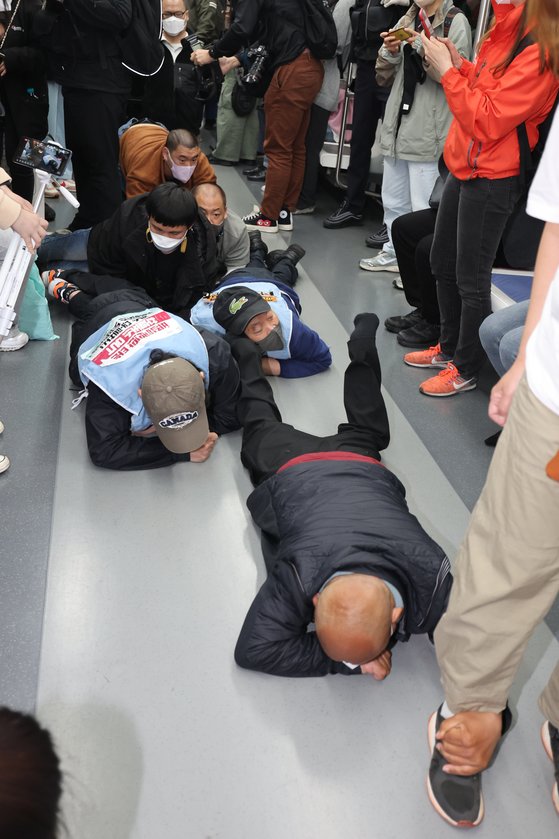 地下鉄２号線で床を這ってデモする障害者（写真聯合ニュース）