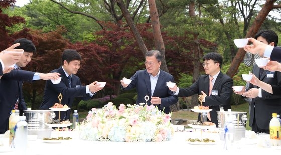 韓国の文在寅（ムン・ジェイン）大統領が２５日、青瓦台（チョンワデ、大統領府）緑芝園（ノクチウォン）で出入り記者団を招いて懇談会を開き、過去５年間の国政運営に対する所感を明らかにした。文大統領と出入り記者がマッコリの杯を持って乾杯している。カン・ジョンヒョン記者