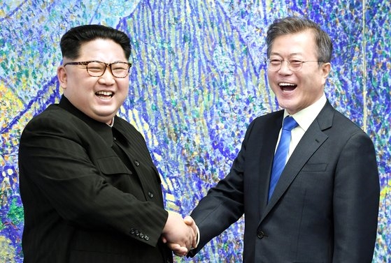 文在寅大統領と北朝鮮の金正恩国務委員長が２０１８年４月２７日に板門店の「平和の家」で南北首脳会談をする前に大笑いしている。「ひたすら平和」を叫んだが平和は定着できなかった。［写真　韓国共同写真記者団］