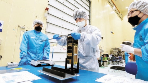ソウル大学研究チームがキューブ衛星「ＳＮＵＧＬＩＴＥ－ＩＩ」を性能検証用衛星に搭載するために検収する姿。［写真　ソウル大学］
