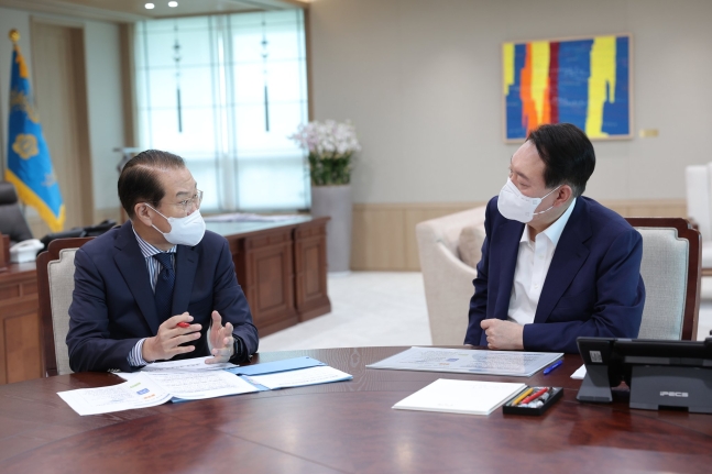 韓国の尹錫悦（ユン・ソクヨル）大統領（右）が２２日、龍山（ヨンサン）大統領室執務室で権寧世（クォン・ヨンセ）統一部長官（左）から業務報告を受けている。［写真　大統領室］