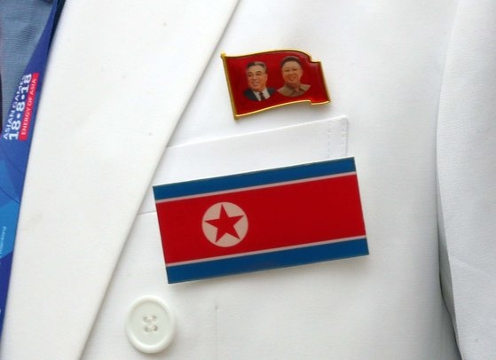 北朝鮮の国旗と金日成・金正日バッジ。［写真　中央フォト］