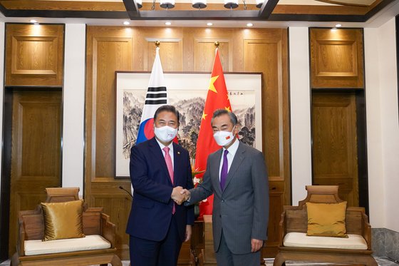 韓国の朴振外交部長官（左）と王毅中国外交担当国務委員兼外交部長が９日、中国青島市の即墨古城君蘭ホテルで握手している。［写真　外交部］