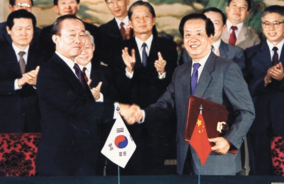 １９９２年８月２４日、北京で韓中修交文書を交換して握手を交わす李相玉（イ・サンオク）外務長官と銭其チェン外相。　［中央フォト］