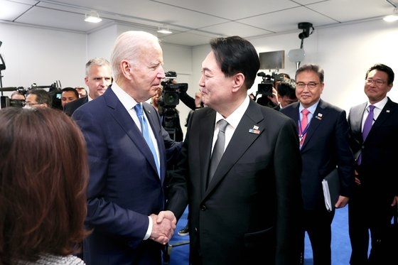 ６月、スペイン・マドリードで開かれたＮＡＴＯ首脳会議期間にバイデン米大統領に会って握手する尹錫悦（ユン・ソクヨル）大統領。尹大統領は就任以降、韓米同盟強化の意志を強調している。　［大統領室提供］