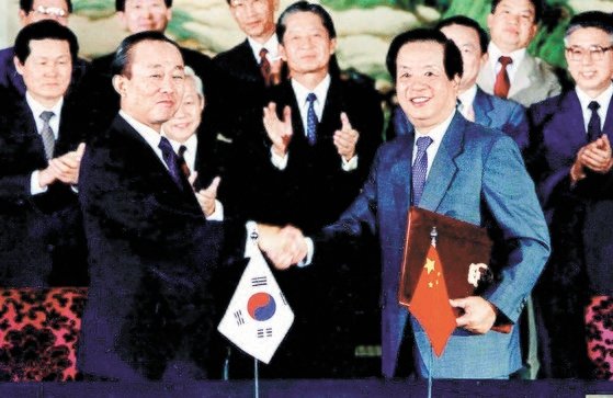 １９９２年８月、李相玉（イ・サンオク）外務長官と銭其チェン外相が韓中修交文書に署名して交換した後、握手する場面。　［中央フォト］