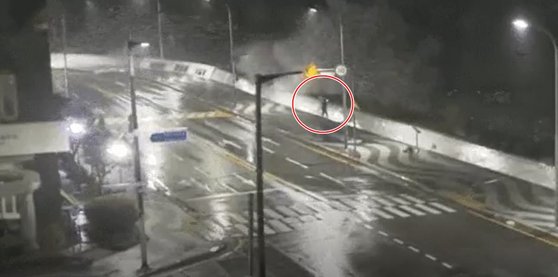 釜山市海雲台区佑洞（プサンシ・ヘウンデグ・ウドン）マリンシティ防波堤の近くで台風の状況を生中継しているユーチューバーの様子。［写真　読者］