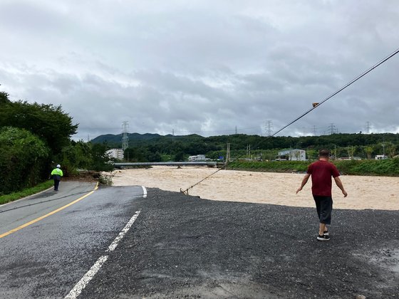 ６日、台風１１号による水害で流出した道路。　写真＝読者