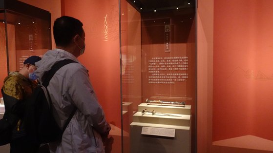 ８日、中国国家博物館で開かれている「東方吉金：中韓日古代青銅器展」を訪れた観覧客が展示中の「漆鞘青銅剣」の説明文を詳しく読んでいる。［写真　シン・キョンジン特派員］