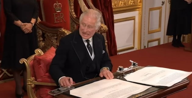 １０日（現地時間）、チャールズ３世が公式文書に署名する前に、机に置かれたペンケースを片づけるように指示する様子。［写真　ツイッター］
