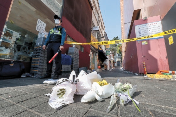 事故犠牲者を追悼する市民が３０日に事故現場に近いソウル・梨泰院のハミルトンホテル前に置かれた弔花の前で酒を注いでいる。キム・ソンリョン記者