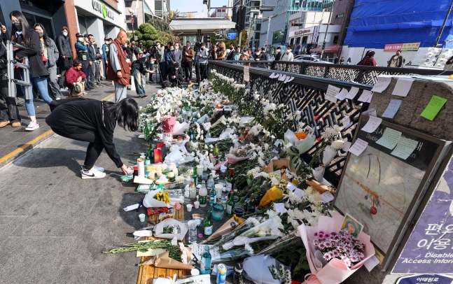 梨泰院事故の犠牲者を追悼するために３１日、ソウル龍山区梨泰院駅１番出口を訪れた市民が追悼の花を供えている。キム・ソンニョン記者