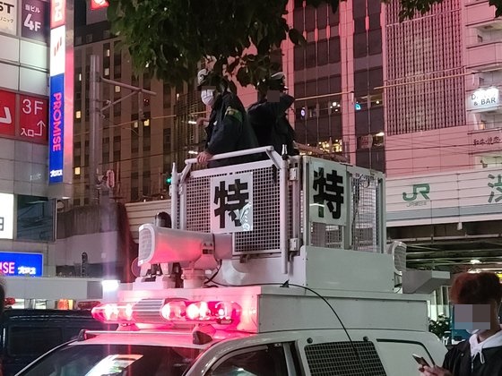 東京渋谷で先月３０日、「ＤＪポリス」が改造したパトカーの上から道行く人々の通行を案内している。［写真　イ・ヨンヒ特派員］
