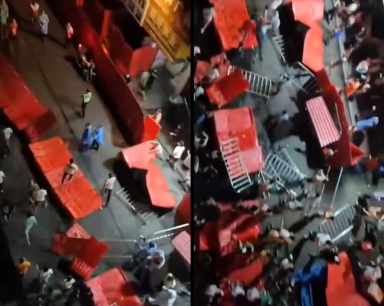 １４日、広州海珠区で封鎖措置に怒った群衆が警察が張り巡らせてあった赤色のバリケードを押し倒したり破壊したりして市街行進をしている。［写真　ツイッター　キャプチャー］