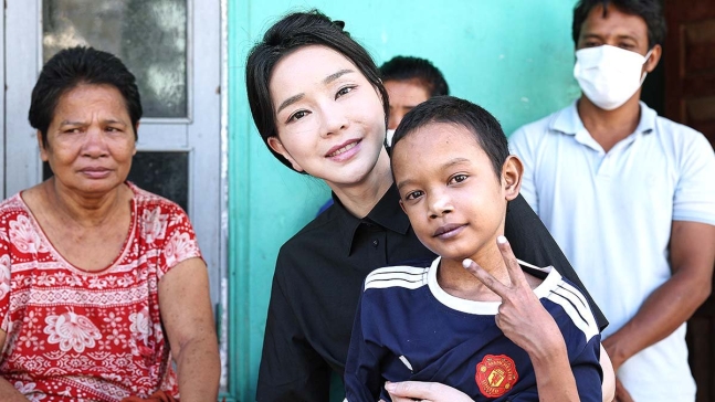 尹錫悦大統領夫人の金建希氏が１２日、カンボジアのプノンペンで先天性心臓疾患を患っている１４歳の子どもの自宅を訪れ、子供を抱いている。［写真　大統領室］