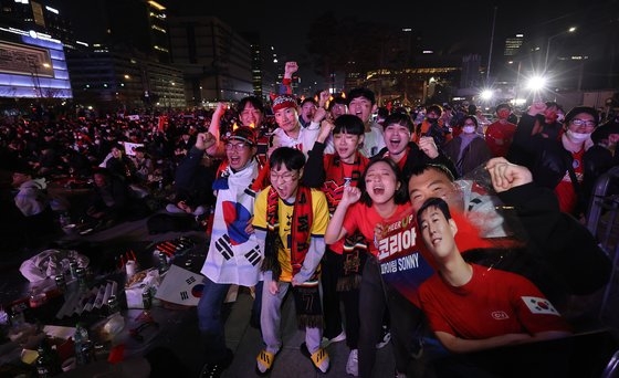 ２４日夜、ソウル光化門広場で赤い悪魔応援団の会員と市民が２０２２ＦＩＦＡカタールＷ杯グループリーグＨ組の大韓民国対ウルグアイ試合開始前に応援歌などに合わせて熱い応援をしている。ウ・サンジョ記者