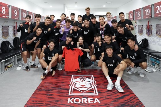 ＢＴＳのジョングク（前列中央）が韓国サッカー代表チームの練習場であるドーハのアル・エグラ・トレーニングセンターを訪れ、孫興民など代表選手たちと記念撮影を行った。［写真　大韓サッカー協会］