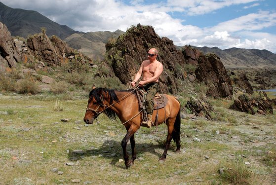 上着を脱いで馬に乗っているプーチン大統領。［写真　ロイター＝聯合ニュース］