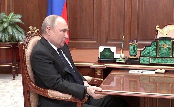 右手で机を強くつかんでいるプーチン大統領。［写真　ロイター＝聯合ニュース］