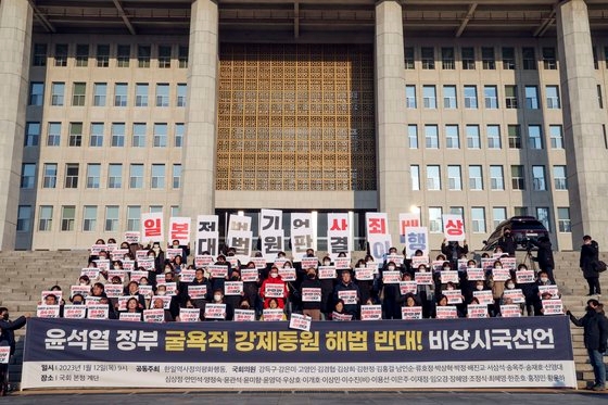 共に民主党・正義党の議員らは強制徴用解決案議論のための討論会直前の１２日午前、国会本庁前の階段で韓日歴史正義平和行動と共に政府の強制徴用解決案に反対する記者会見を開いた。　キム・ソンリョン記者