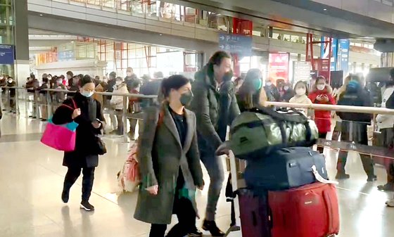 ８日、中国北京首都空港の到着ロビーを施設隔離なく通過する外国人の家族　北京＝パク・ソンフン特派員