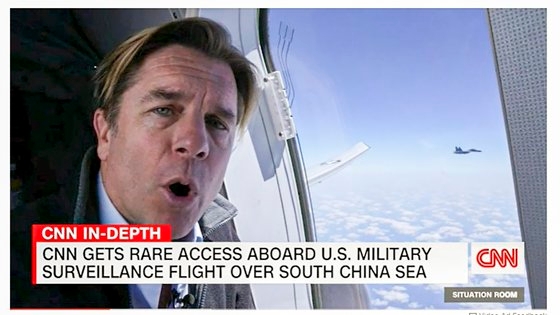 近接した中国戦闘機を見ながら実況を伝えるＣＮＮ記者。［写真　ＣＮＮ　キャプチャー］