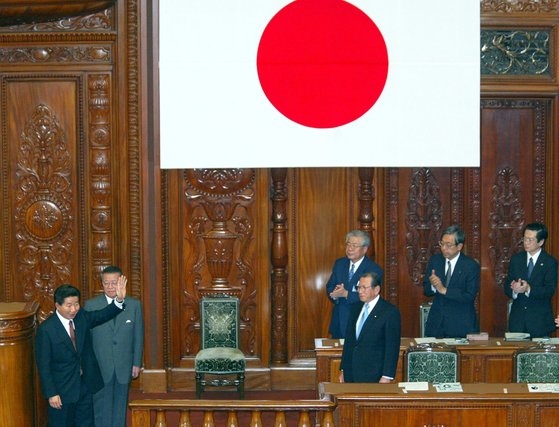 ２００３年６月９日午前、日本国会議事堂で演説を終えた盧武鉉（ノ・ムヒョン）大統領が議員の起立拍手に手をあげて応えながら議事堂を離れている。［写真　青瓦台写真記者団］