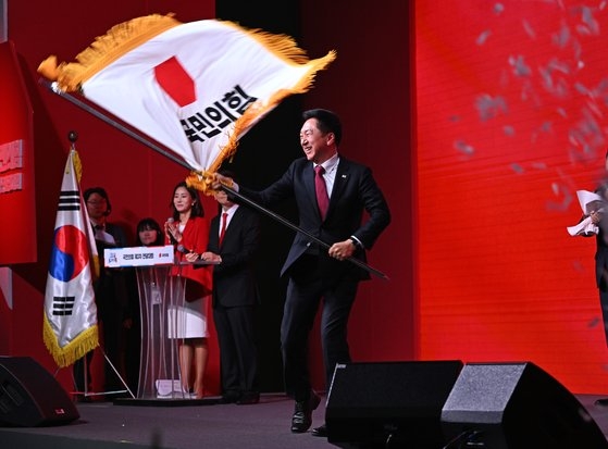 国民の力の金起炫新任代表が８日、京畿道高陽市ＫＩＮＴＥＸで開かれた全党大会で代表に選出された後、党旗を振っている。チャン・ジニョン記者