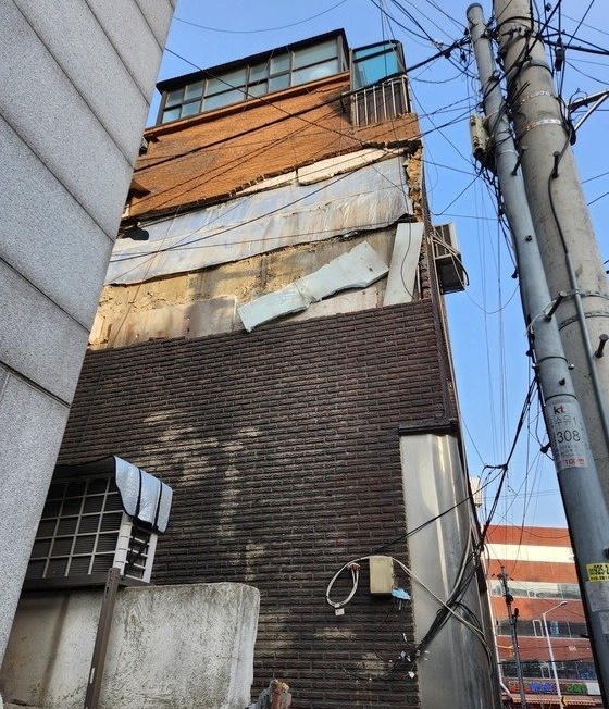 ２３日午後、ソウル江北区水踰洞のある４階建てアパートの外壁の一部が崩れ落ちた様子。［写真　ソウル江北消防署］