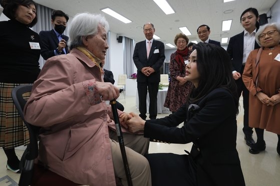 金建希夫人が１２日、京畿道坡州市の国立韓国戦争拉致被害者記念館で拉致被害者・抑留者家族のキム・テオクさんの手を握って慰めている。［写真　大統領室］