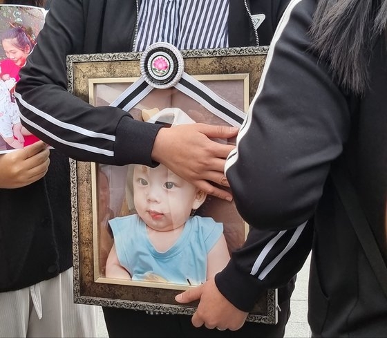 京畿道華城市のある保育園で発生した児童虐待犯罪で死亡したチョン・ドンミンくん（当時生後９カ月）の母親ボティ・ニュンさん（２６）が、息子の遺影を撫でている。チェ・モラン記者
