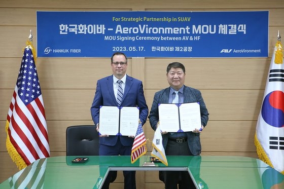 韓国ファイバー（Hａｎｋｕｋ　Fｉｂｅｒ）のチョ・サンホ副社長（右）とエアロバイロンメント（ＡｅｒｏＶｉｒｏｎｍｅｎｔ）のトレース・スティーブンソン（Ｔｒａｃｅ　Ｓｔｅｖｅｎｓｏｎ）上級副社長が１７日、軍用無人機生産協力のための了解覚書（ＭＯＵ）を締結した。［写真　韓国ファイバー］