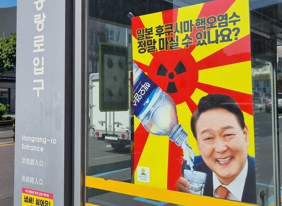  核汚染水をコップに受ける尹錫悦大統領が合成されたポスター（聯合ニュース)