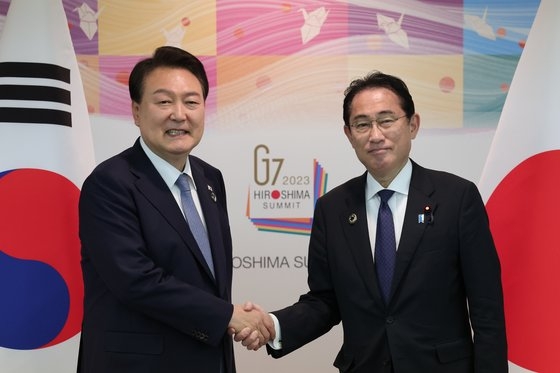主要７カ国（Ｇ７）サミットに出席するために日本を訪問中の尹錫悦大統領が２１日、広島平和記念公園国際会議場で開かれた韓日首脳会談で岸田文雄首相と握手している。［写真　大統領室］