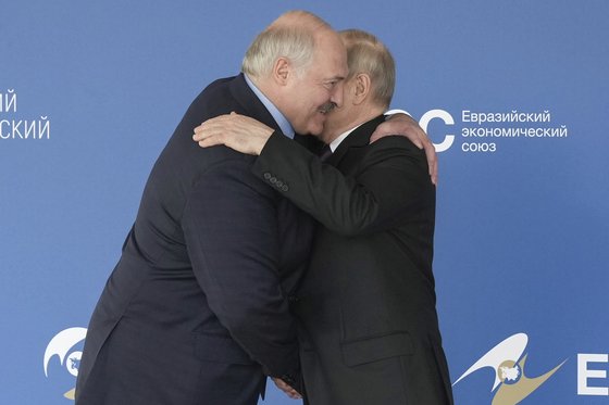 プーチン露大統領と抱擁を交わすベラルーシ大統領（左）／ＡＰ＝聯合ニュース