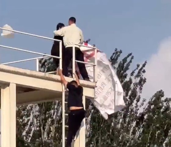 ３日、北京オリンピック（五輪）公園で一人の女性が星条旗を振ろうとしたところ警備要員に取り押さえられた。［写真　ツイッター　キャプチャー］
