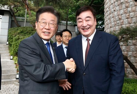 韓国最大野党「共に民主党」の李在明（イ・ジェミョン）代表（左）が８日、ソウルの中国大使官邸を訪問して邢海明駐韓大使と握手している。李代表と邢大使は「福島汚染水海洋放流」阻止対策などを話し合った。キム・ヒョンドン記者