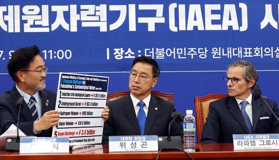 国際原子力機関（ＩＡＥＡ）のグロッシ事務局長が９日午前、ソウルの国会で「共に民主党」の魏聖坤福島原発汚染水海洋投棄阻止対策委員会委員長をはじめとする委員らと面談している。左側の禹元植議員が持つパネルは汚染水処理５種類の方法のうち海洋放流の費用が最も少ないという内容だ。キム・ソンリョン記者