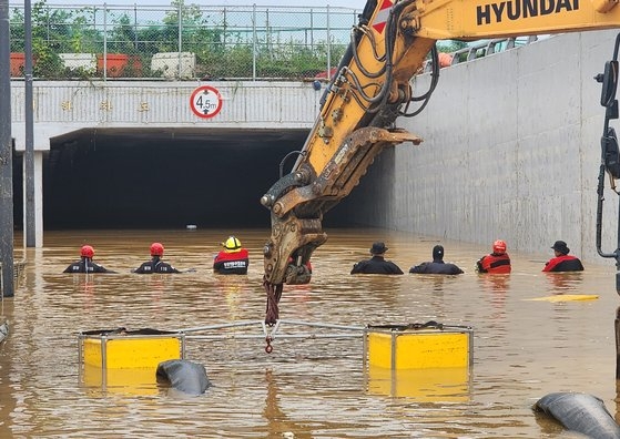 大雨で浸水した忠清北道清州市興徳区五松邑（チュンチョンブクド・チョンジュシ・フンドク・オソンウプ）の宮坪（クンピョン）第２地下車道で消防関係者が行方不明者の捜索活動を行っている。［写真　韓国消防庁］