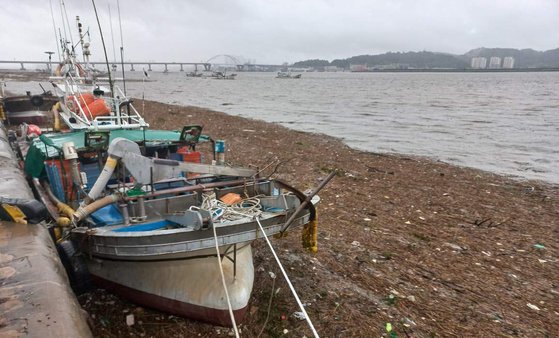 長項港に豪雨で押し寄せたゴミが堆積し、漁船が出航できなくなった。［写真　韓国舒川郡］
