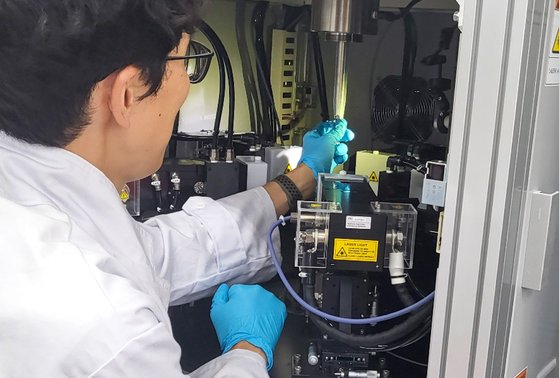 韓国原子力研究院先端量子素材研究室のキム・ジェウク博士が高品質のテルビウムインジウム酸化物（ＴｂＩｎＯ３）単結晶を合成するために使用されるレーザー浮遊帯域溶融装置を点検している。　写真＝韓国原子力研究院