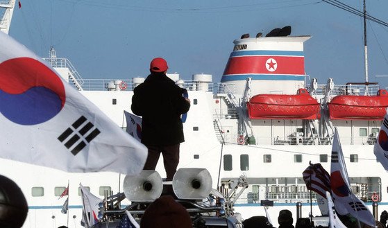 ２０１８年２月６日、平昌冬季五輪に参加した北朝鮮芸術団を乗せた「万景峰９２号」が墨湖（ムッコ）港に入港する様子。当時、保守団体の会員たちは太極旗を振りながら反発した。［中央フォト］