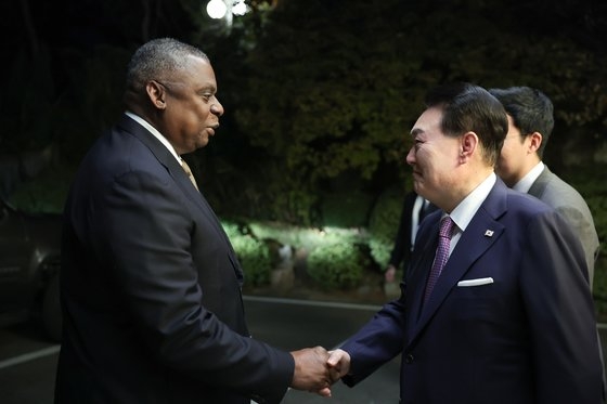 尹錫悦大統領が１２日、ソウル漢南洞の官邸でロイド・オースティン米国防長官と握手している。尹大統領は同日、韓米安保協議会議（ＳＣＭ）の米側代表団を激励し、晩餐を開いた。［写真　大統領室］