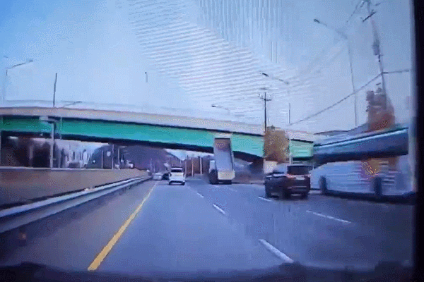 荷台が橋梁の下にひっかかったダンプトラック。［映像　事故当時のドライブレコーダー映像。オンライン　コミュニティ　キャプチャー］