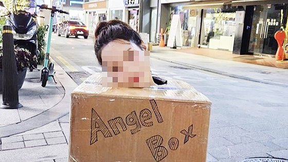 昨年１０月、狎鴎亭（アックジョン）や弘大（ホンデ）などソウルの繁華街に出没し、裸に段ボール箱だけをかぶった自分の体を触るように通行人に声をかけていた女性。［写真　インスタグラム　キャプチャー］