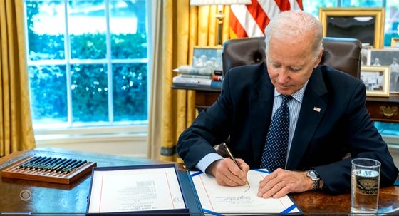 スパイ道具として利用される可能性が疑われてきた中国製コンテナクレーンに対して、米国のバイデン大統領が強力なサイバーセキュリティを要求する行政命令に２１日（現地時間）、署名する。写真は昨年６月４日、財政責任法案に署名するバイデン大統領。中央フォト