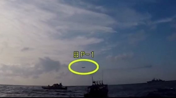 韓国国防部が今月４日、韓日「レーダー問題」をめぐる日本側の主張に反論する動画をユーチューブに公開した。当時、遭難船救助作戦中だった韓国駆逐艦「広開土大王」の上空を低高度で飛行した日本の哨戒機（黄色の円）を韓国海警が撮影した。［国防部　ユーチューブ　キャプチャー］