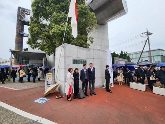 ３日午前、東京都目黒区の東京工業大学キャンパスで入学式が開かれた中、新入生と家族が校名の書かれた正門前で記念写真を撮っている。