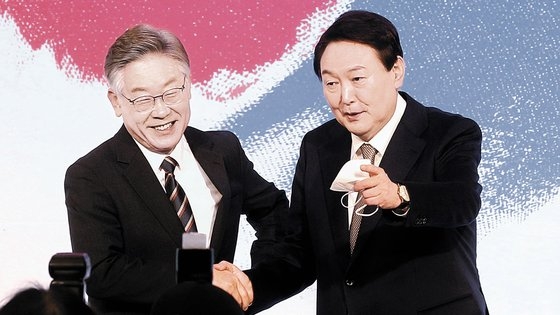 大統領選挙を控えた２０２１年１２月、ソウル鍾路区フォーシーズンズホテルで開かれた中央フォーラムで握手をする尹錫悦（ユン・ソクヨル）大統領と李在明（イ・ジェミョン）共に民主党代表　カン・ジョンヒョン記者